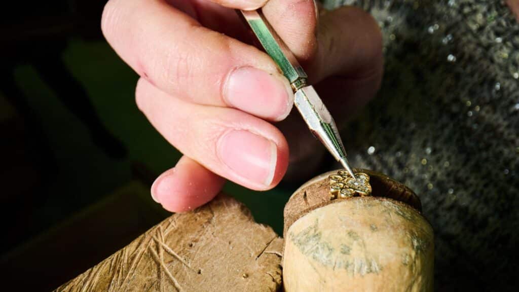 Italian artisan setting a gold charm by hand, reflecting fine craftsmanship and care.