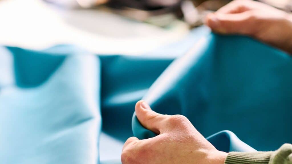 Hands assessing fine Italian leather, selected for quality and durability.